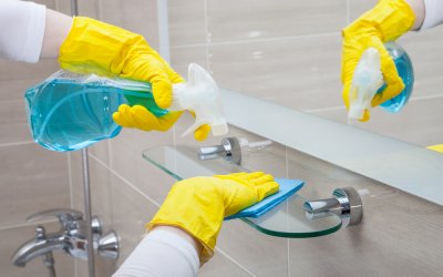 Housemaid wearing yellow gloves cleaning the bathroom
