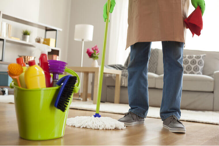 Man holding mop and plastic bucket