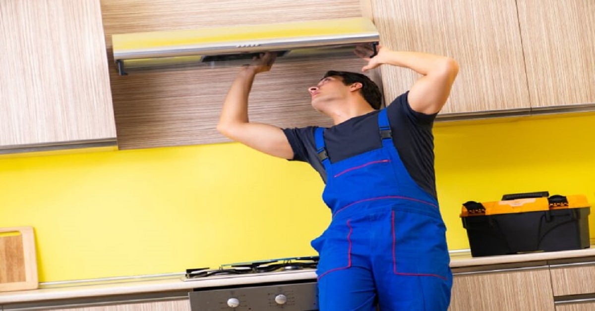 Young service contractor assembling kitchen furniture