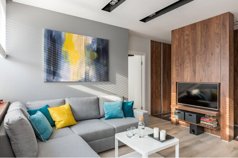 Living room with large sofa, coffee table, tv and wooden wall Living room with large sofa, coffee table, tv and wooden wall