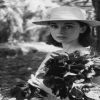 Audrey Hepburn with a hat holding flowers
