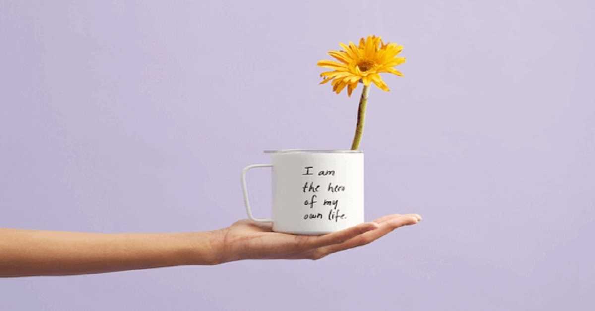 hand holding a mug with flower