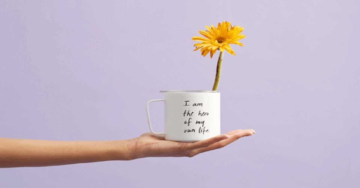 hand holding a mug with flower hand holding a mug with flower