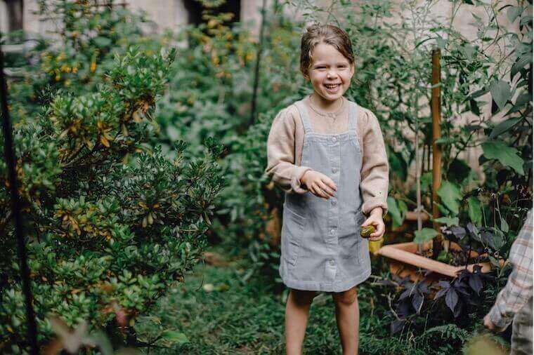 happy child smiling while in garden holding a seed happy child smiling while in garden holding a seed