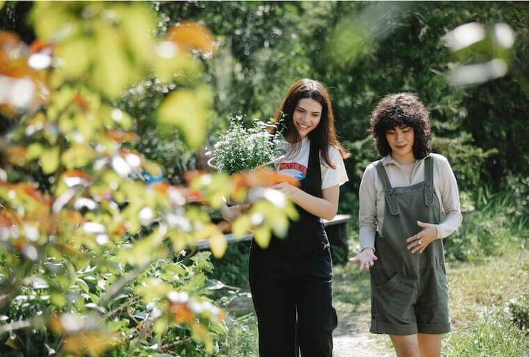 two happy friends walking in a garden