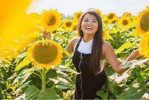 woman smiling in a field of sunflowers