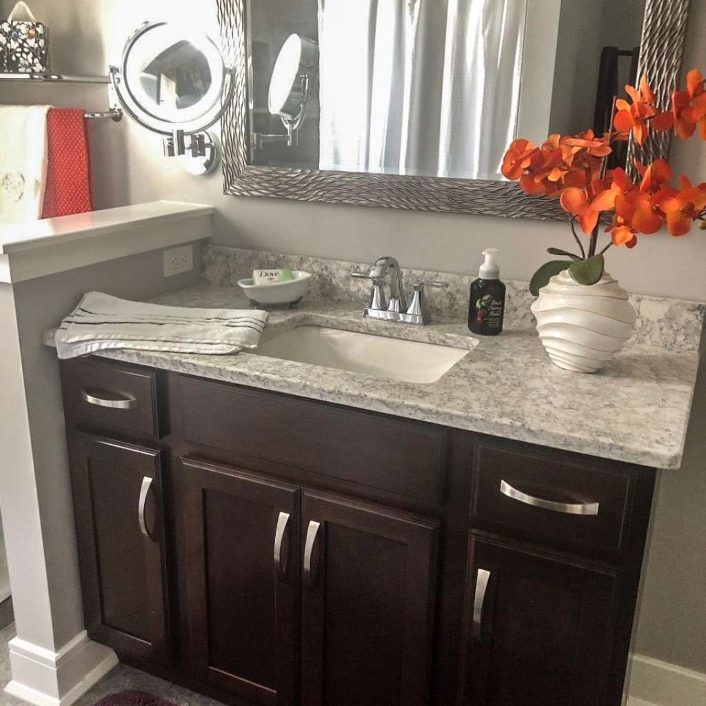 A cherry vanity with a marble countertop