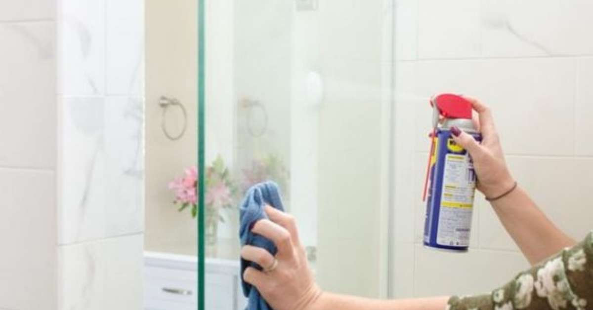 a lady cleaning shower screen with WD-40 a lady cleaning shower screen with WD-40