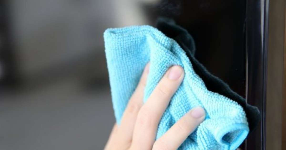 wiping a flat screen tv with a microfibre cloth wiping a flat screen tv with a microfibre cloth