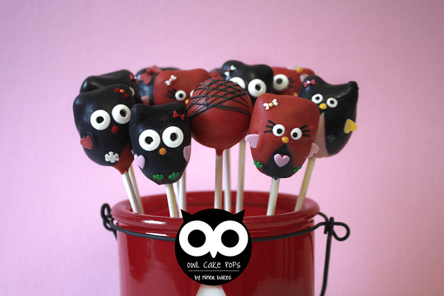 Owl-themed birthday cake pops in colors red and black with a pink backdrop