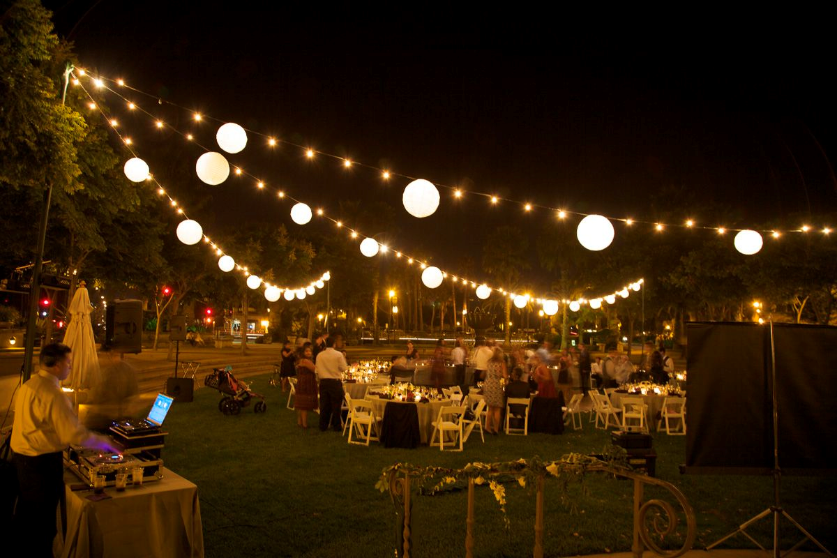 A backyard movie night under a string of lights 