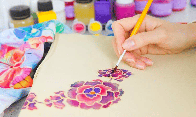 A person painting on a fabric