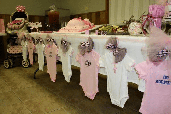 Baby shower decorations adorned with baby clothes