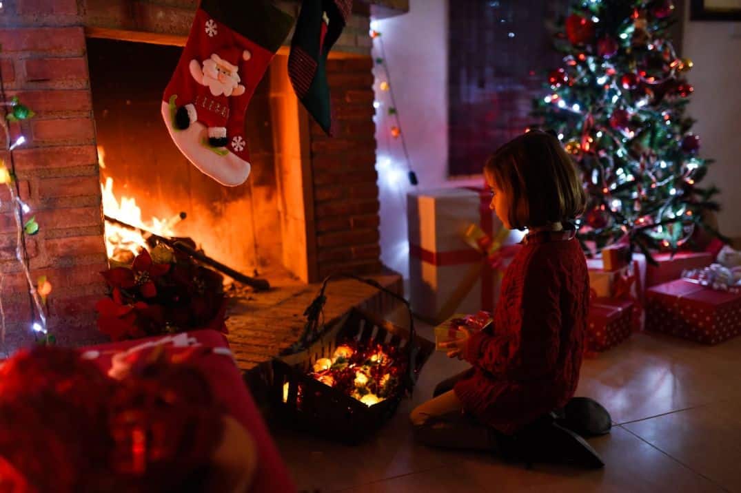 Little girl decorating christmas fireplace