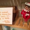 Mischievous elf on the shelf with a written note