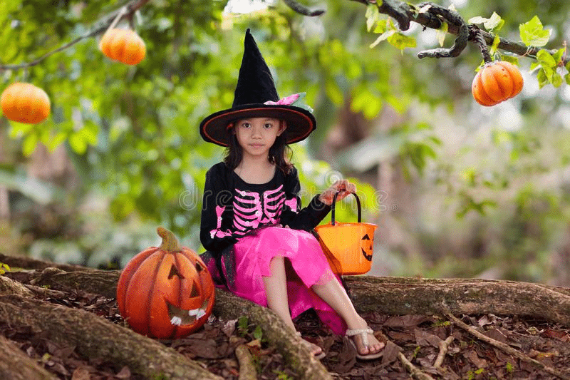 Halloween-themed photoshoot for a child in a witch costume