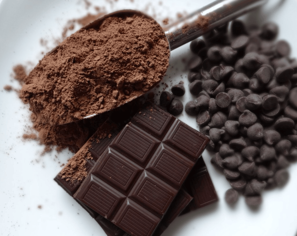 Chocolate powder, a bar of chocolate, and chocolate chips Chocolate powder, a bar of chocolate, and chocolate chips