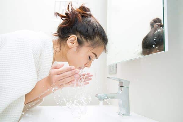 A lady cleansing her face at home