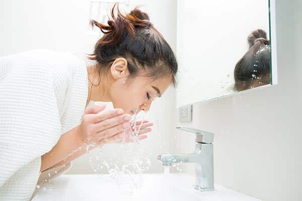 A lady cleansing her face at home A lady cleansing her face at home