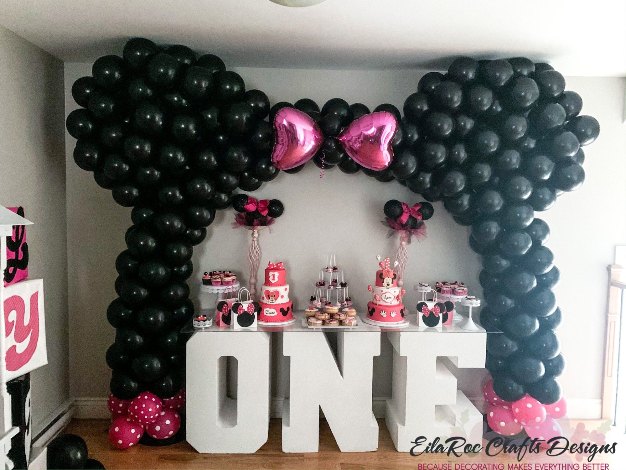 Minnie-mouse-themed birthday party balloon arch 